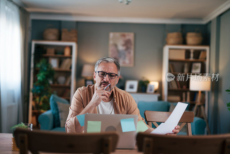 一个成熟的男人拿着一张纸，神情沉思。