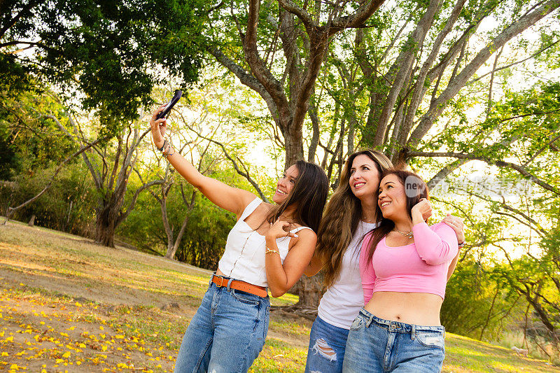 三位西班牙裔女性朋友穿着随意，在户外自拍或自拍