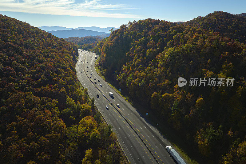 鸟瞰图:金秋时节，北卡罗莱纳州I-40高速公路穿过阿巴拉契亚山脉，通往阿什维尔，沿途有快速行驶的卡车和汽车。州际运输概念