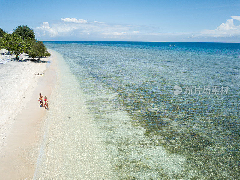 鸟瞰热带海滩上的年轻情侣享受度假和大自然，人们旅游探险的理念