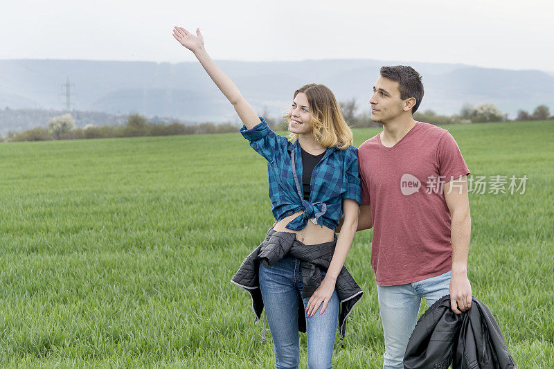 一对情侣在田野里散步，玩得开心。