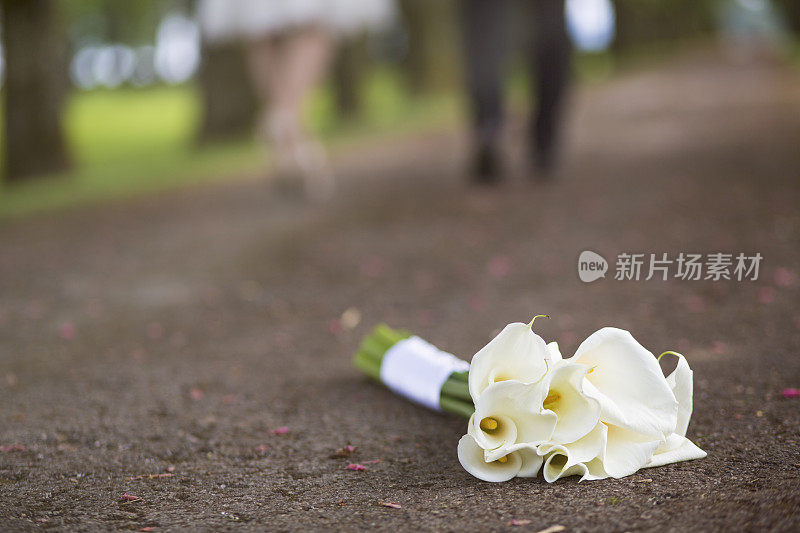 婚礼花束躺在地上，新婚夫妇离开