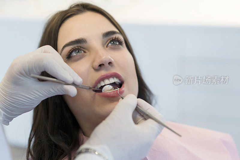 年轻女子正在牙医那里检查牙齿