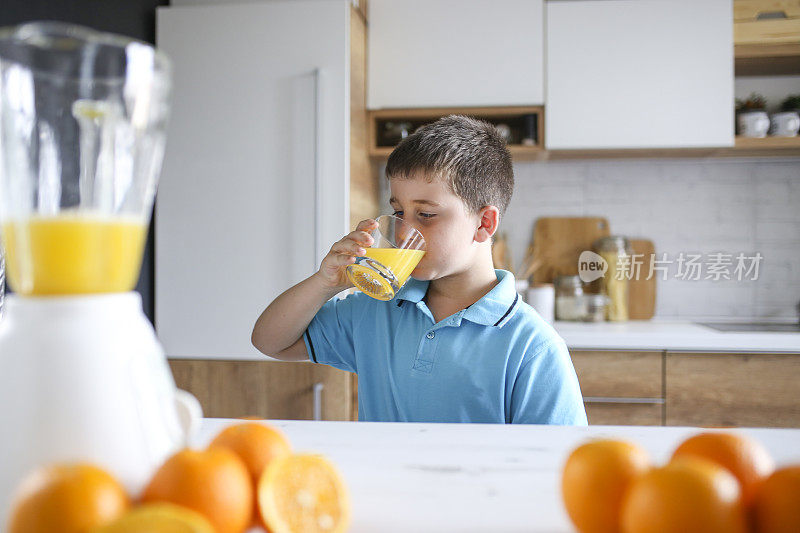 喝新鲜橙汁的男孩