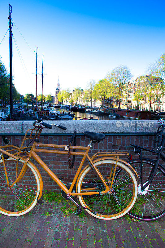 荷兰阿姆斯特丹:停放在运河附近的两辆旧自行车