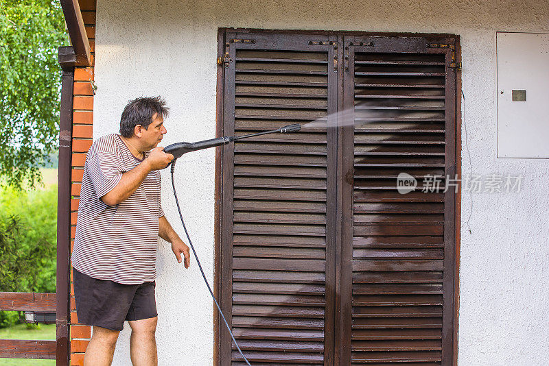 男人用喷水器清洁房屋