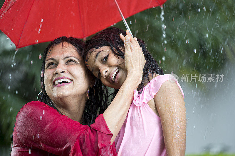 快乐的母亲和女儿在雨中