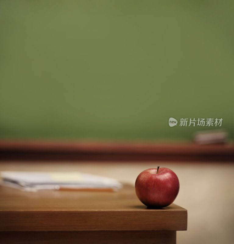 红苹果在老师的桌子上。