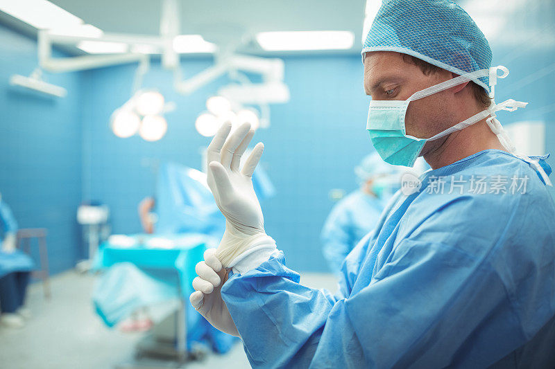男外科医生在手术室戴着手术手套