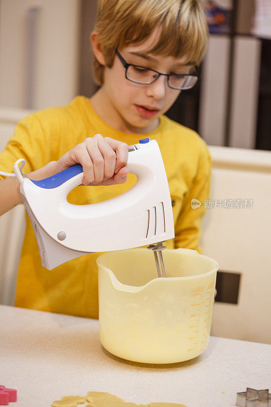 用电动搅拌器的男孩