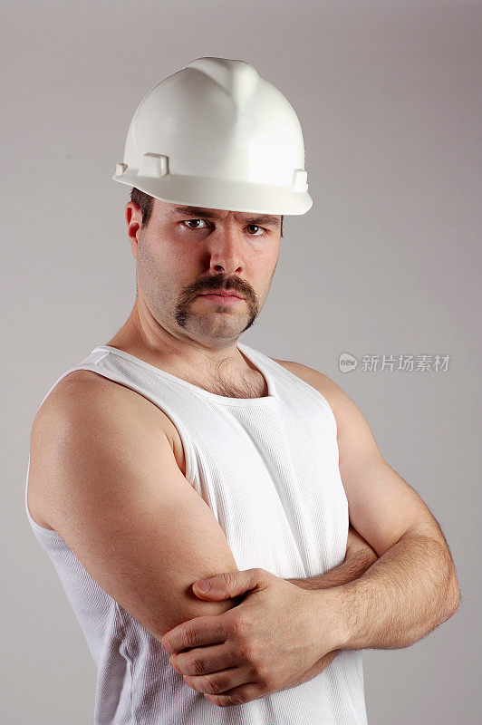 穿着无袖衬衫的严肃建筑工人