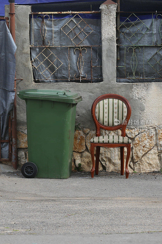 人行道上软垫椅子旁边的垃圾桶