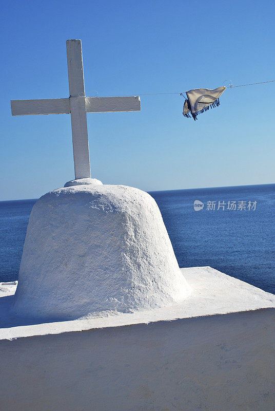 白色十字架的希腊教堂，蓝色的大海为背景