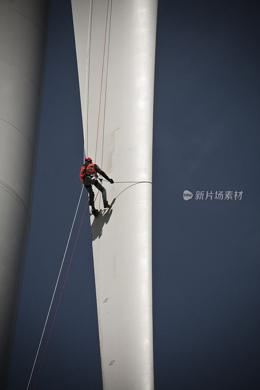 一名工人正在攀爬一座高层建筑