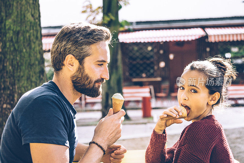 年轻的父亲和女儿在柏林大街上吃冰淇淋