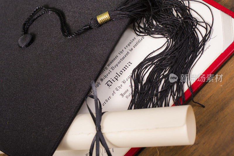 毕业!桌上放着学士学位帽、学士帽和流苏。教育。