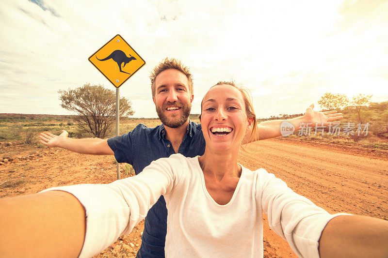 澳大利亚一对年轻夫妇站在袋鼠标志附近的自拍