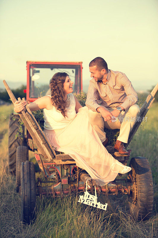 一对新婚夫妇坐在拖拉机上