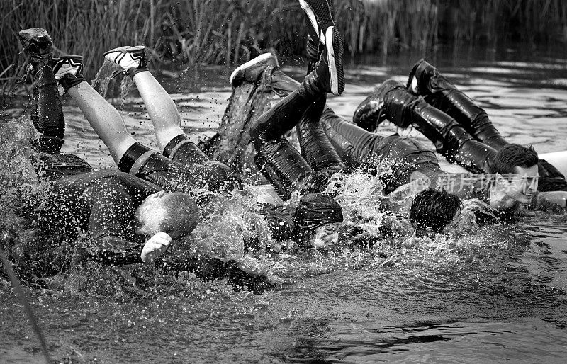 全家在泥浆赛跑活动中从圆木上跳水