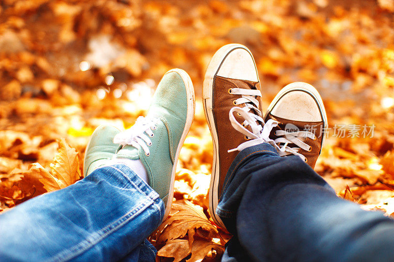一个男人和一个女人的鞋子躺在一堆树叶上