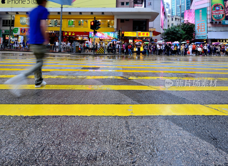 在雨中穿过香港街道的行人的动作模糊了