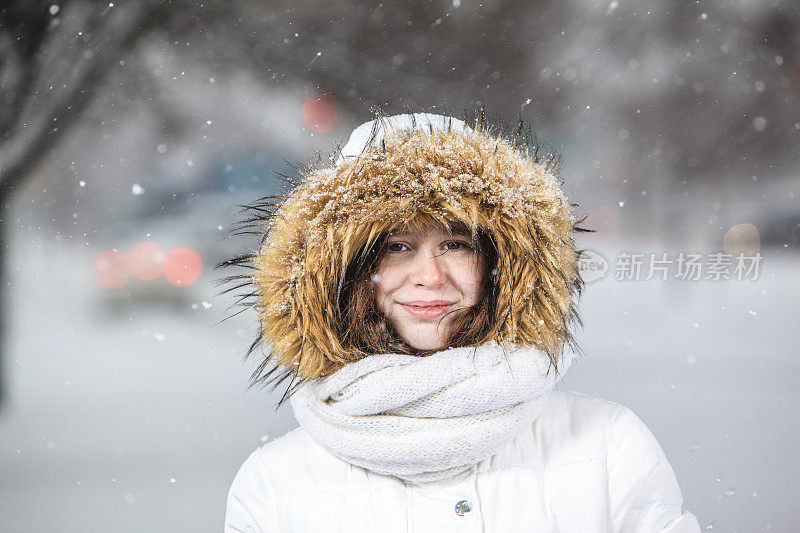 雪下穿着白色夹克的漂亮少女