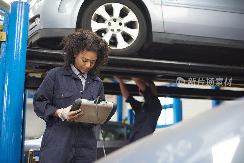 女汽车修理工进行诊断检查。
