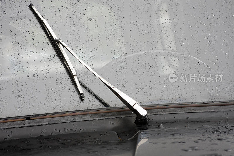 湿的汽车挡风玻璃和雨刷的黑白照片