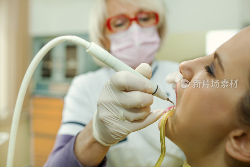 牙科医生在病人的牙齿上使用牙科治疗紫外线灯的特写部分视图