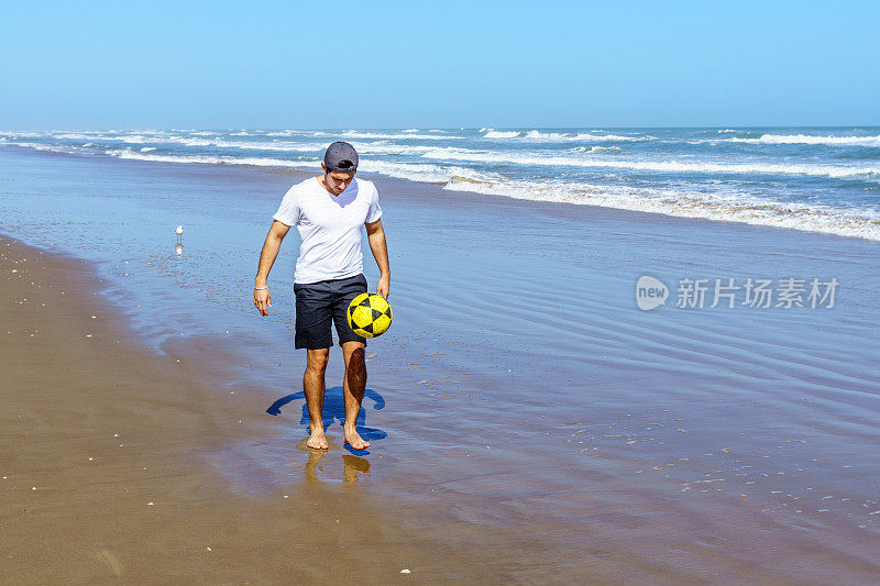 巴西人在沙滩上拿着球