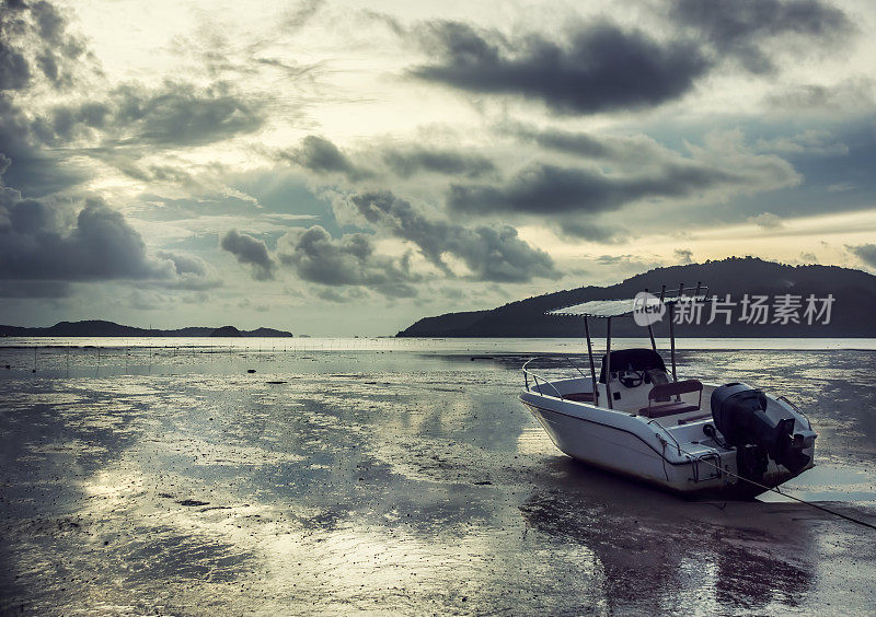 孤独的白色摩托艇在日出时搁浅在安达曼海