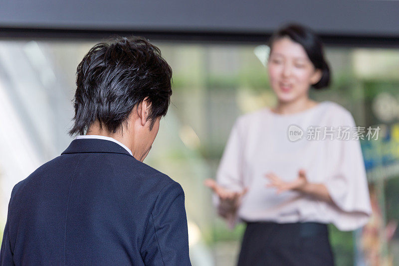 一个日本商人正在听一个女人的谈话