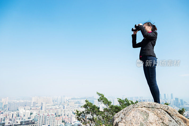 女商人用双筒望远镜看风景