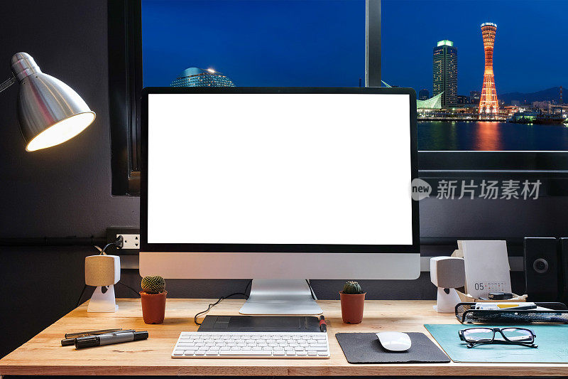 平面设计师的工作空间配备了一个手写板，一台电脑和白色的文本屏幕，从窗口可以看到美丽的神户天际线