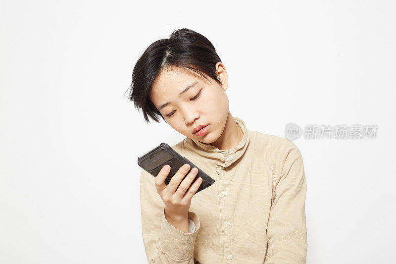 一间工作室拍摄了一名年轻女子用智能手机聊天的照片