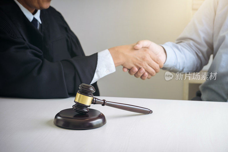 手的形象，男性律师或法官和客户握手后，在现代办公室附近的木槌，法律服务的概念，法律，法律咨询