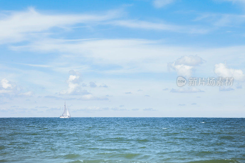 波罗的海，多云的天空和地平线上的小船