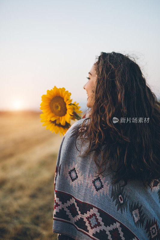 可爱的时髦女孩拿着一束向日葵