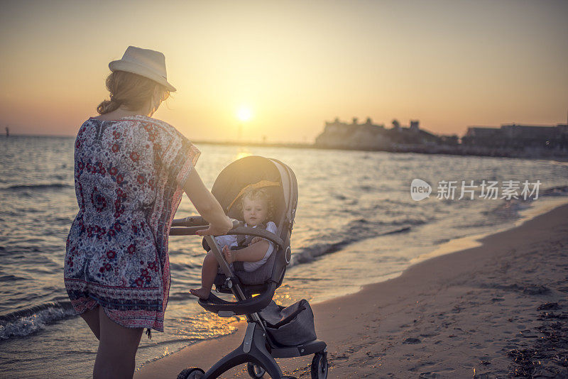 妈妈推着婴儿车在海滩上