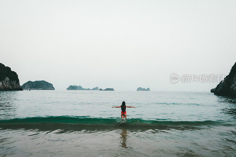 一个女人在越南的海滩上遇见日落