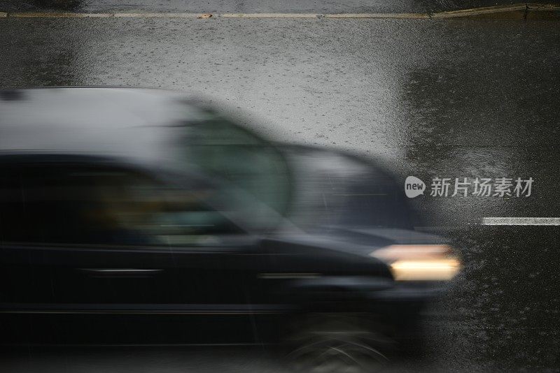 倾盆大雨时汽车在路上行驶