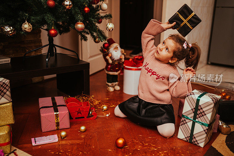 小女孩在家里打开圣诞礼物