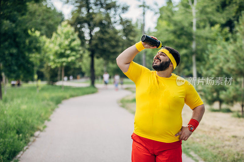 一个超重的男人往他脸上泼水