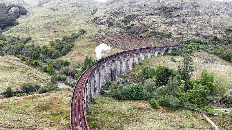 蒸汽火车穿过格伦芬南高架桥，无人机鸟瞰图-苏格兰，英国