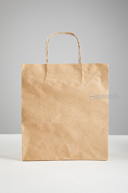 纸质购物袋孤立在灰色，黑色星期五的概念