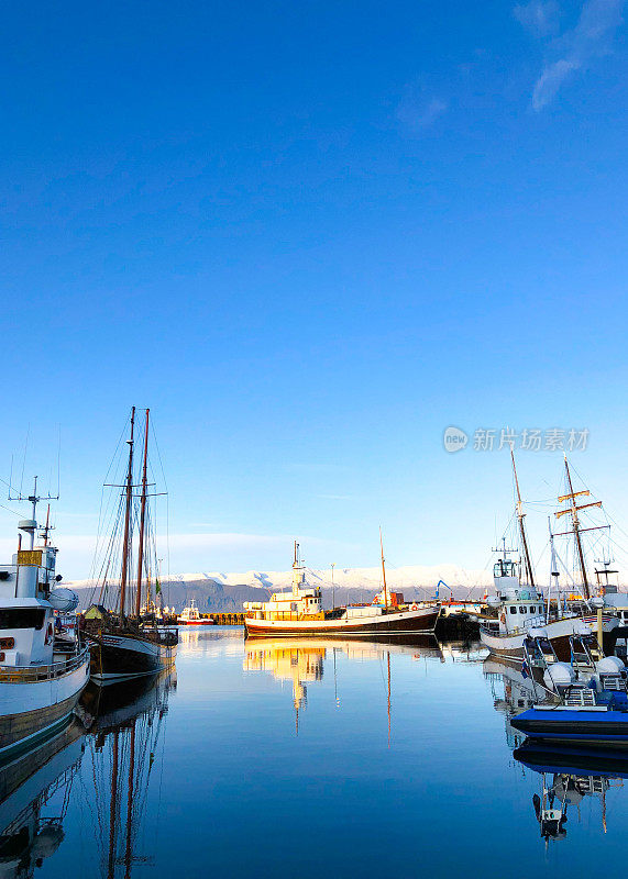 Húsavík，冰岛:清晨阳光明媚的港口里的小船