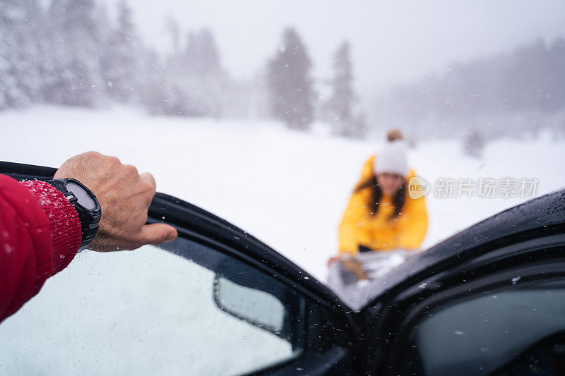 司机的POV驾驶在积雪覆盖的道路上，被困在了第一个下雪的道路上。推着车的女人。冬季暴风雪天气耽搁了。山里有暴风雪。