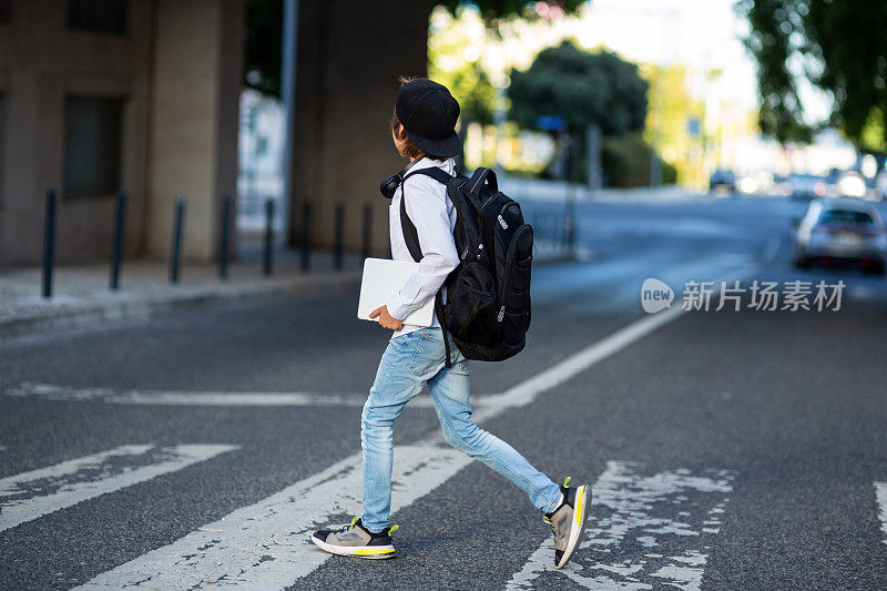 小学生背着背包过马路