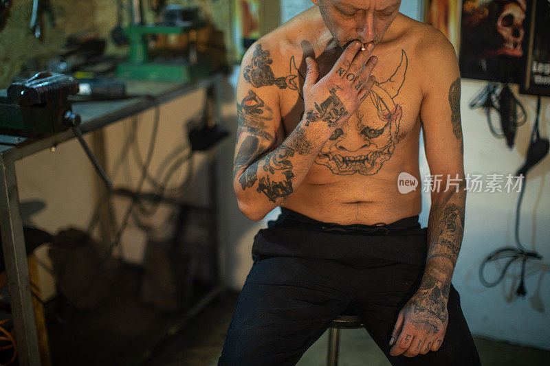 纹身男子在他的工作室吸烟