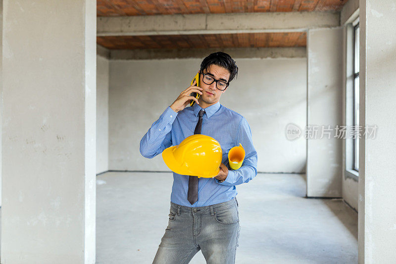 土木工程在建筑工地工作时使用智能手机。